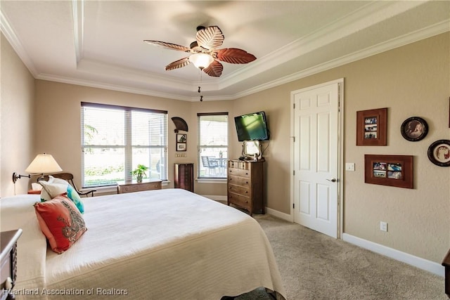 bedroom with crown molding, light carpet, ceiling fan, and a tray ceiling