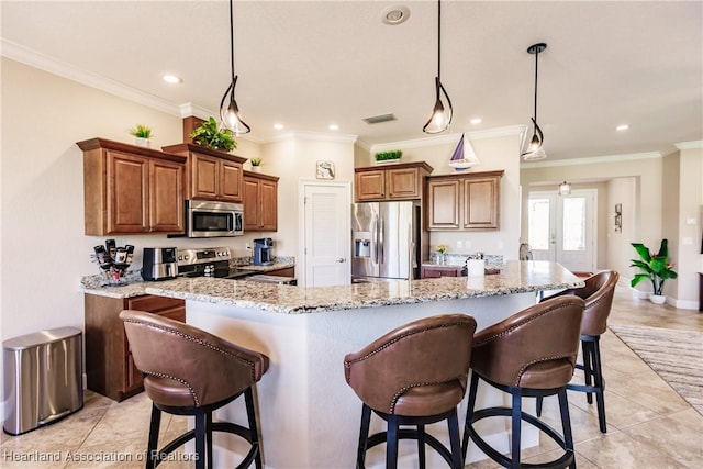 kitchen featuring pendant lighting, stainless steel appliances, a kitchen breakfast bar, and light stone counters