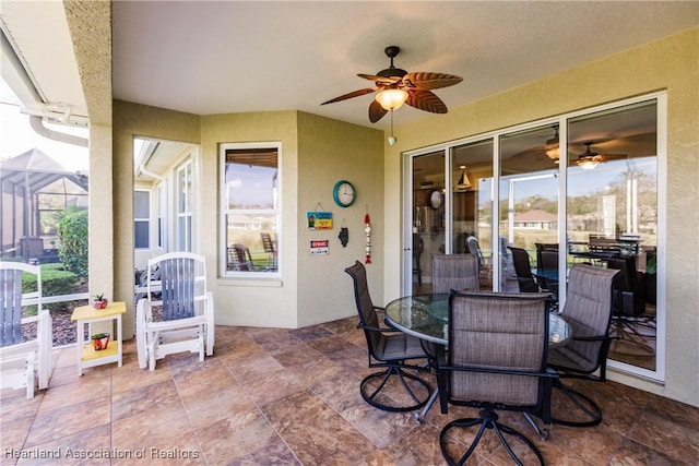 view of patio featuring ceiling fan and a lanai