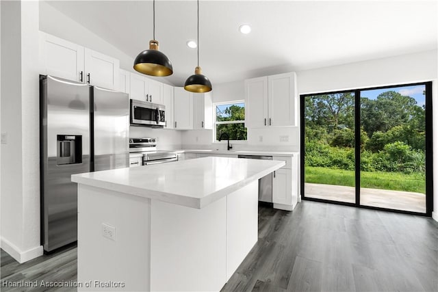 1502 Oak Ave, Lake Placid, FL 33852 - kitchen featuring stainless steel appliances, a kitchen island, light countertops, white cabinetry, and dark wood-style floors