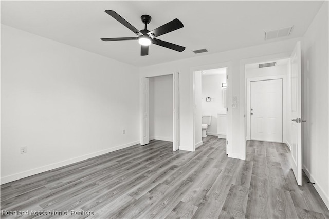 1502 Oak Ave, Lake Placid, FL 33852 - unfurnished bedroom featuring light wood finished floors, baseboards, connected bathroom, and a ceiling fan