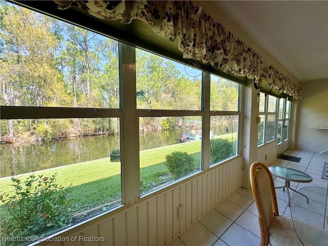 sunroom featuring a water view