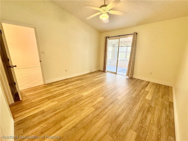 empty room with vaulted ceiling, light wood-style flooring, baseboards, and ceiling fan