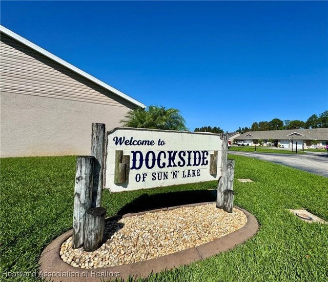 community / neighborhood sign featuring a lawn