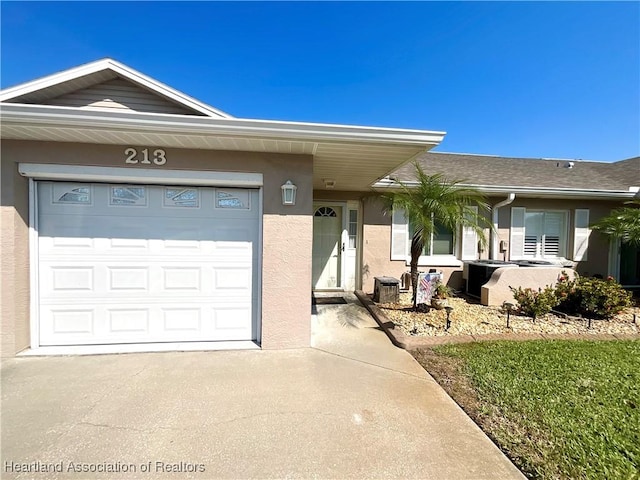 single story home with a garage, concrete driveway, and stucco siding