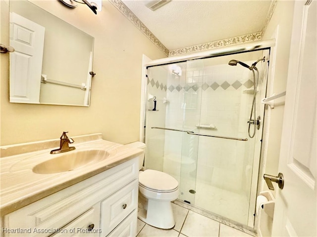 bathroom with tile patterned flooring, toilet, a stall shower, a textured ceiling, and vanity