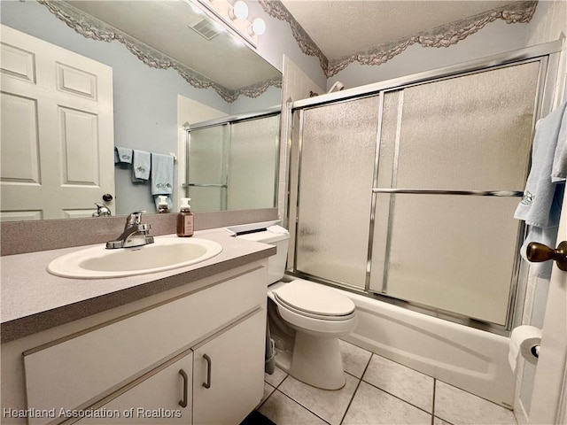 bathroom with vanity, visible vents, enclosed tub / shower combo, a textured ceiling, and tile patterned floors