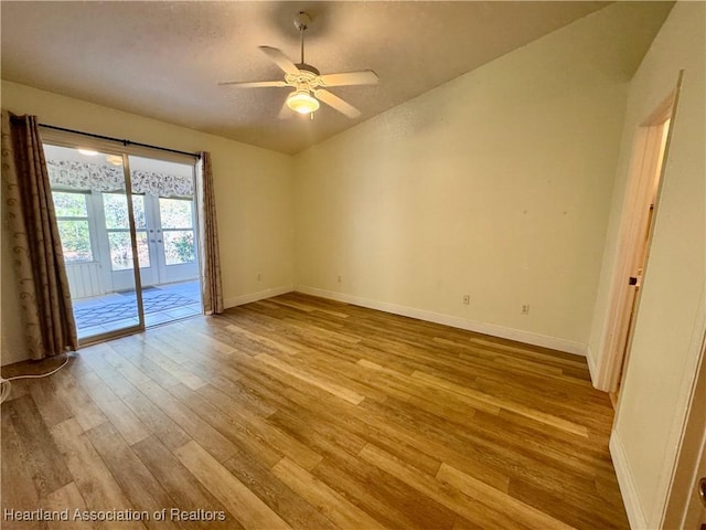 unfurnished room featuring a textured ceiling, wood finished floors, french doors, baseboards, and ceiling fan