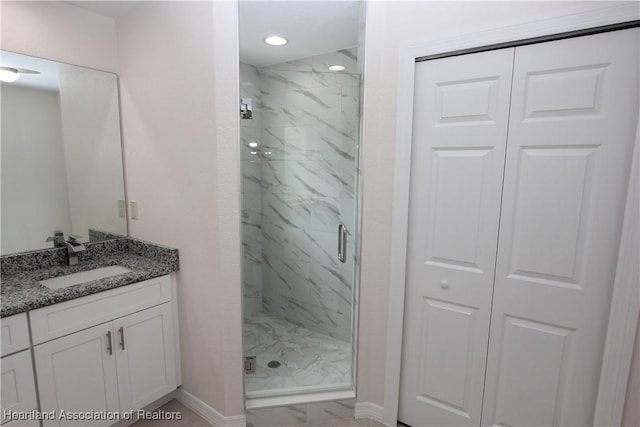 bathroom featuring vanity and a shower with door