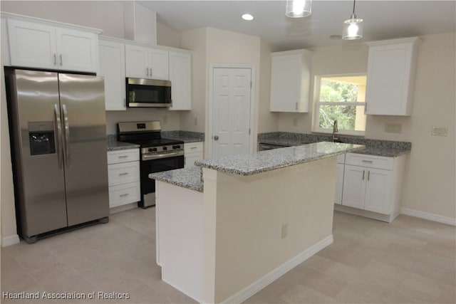 kitchen with a center island, sink, hanging light fixtures, white cabinetry, and stainless steel appliances