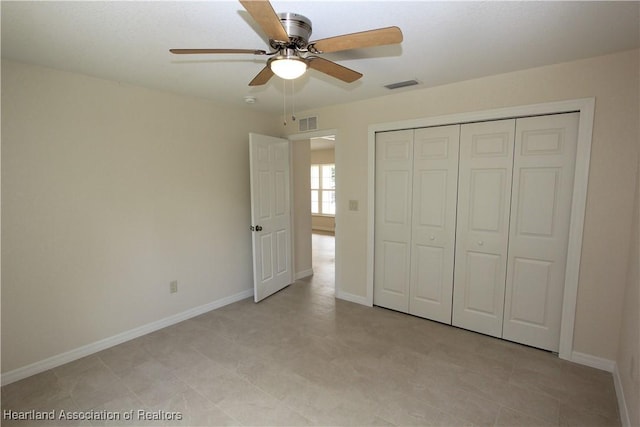 unfurnished bedroom with ceiling fan and a closet