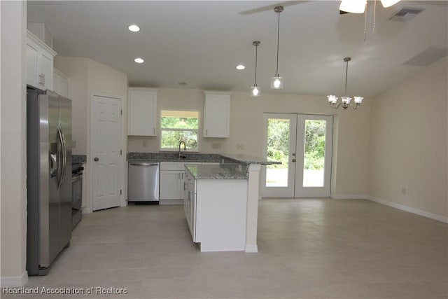 kitchen with white cabinets, pendant lighting, and stainless steel appliances