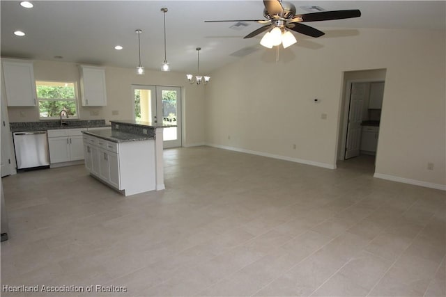 kitchen featuring white cabinets, dark stone counters, ceiling fan with notable chandelier, dishwasher, and a center island