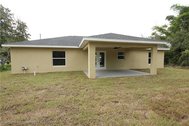 rear view of property with a patio area, ceiling fan, and a yard