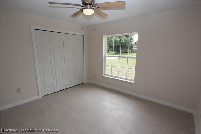 unfurnished bedroom with ceiling fan and a closet