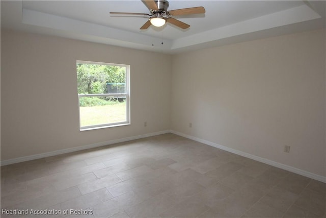 empty room with a tray ceiling and ceiling fan