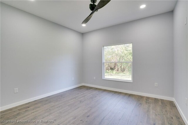 spare room with ceiling fan and light wood-type flooring