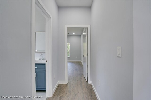 hall featuring sink and light hardwood / wood-style floors