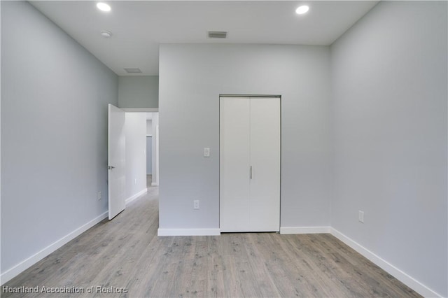 unfurnished bedroom with light hardwood / wood-style flooring and a closet