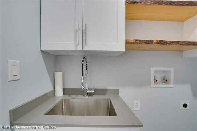 washroom featuring hookup for an electric dryer, cabinets, sink, and washer hookup