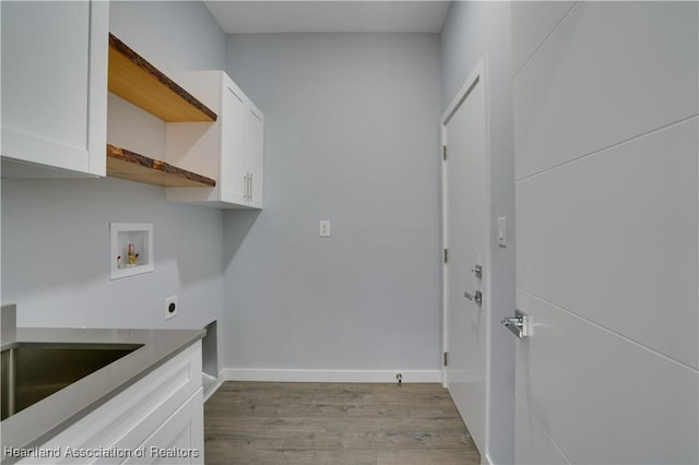 laundry room with hookup for a washing machine, light hardwood / wood-style flooring, cabinets, and hookup for an electric dryer