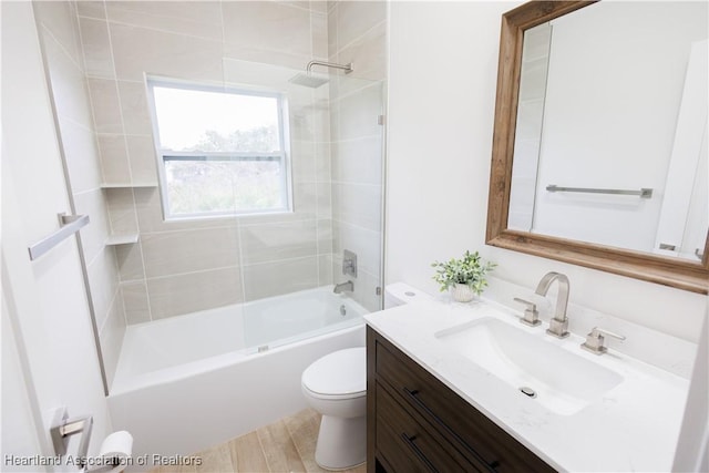 full bathroom with vanity, tiled shower / bath combo, and toilet