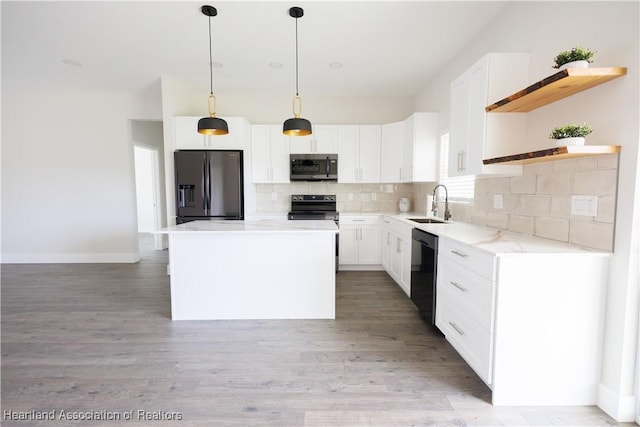 kitchen featuring pendant lighting, black appliances, a kitchen island, white cabinets, and sink