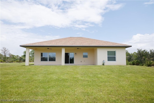 back of property featuring ceiling fan and a lawn