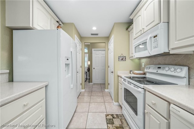 kitchen featuring white cabinets, light tile patterned flooring, white appliances, and backsplash