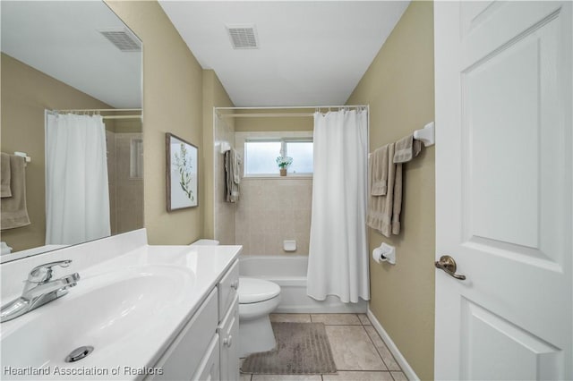 full bathroom with tile patterned floors, shower / bath combo with shower curtain, vanity, and toilet