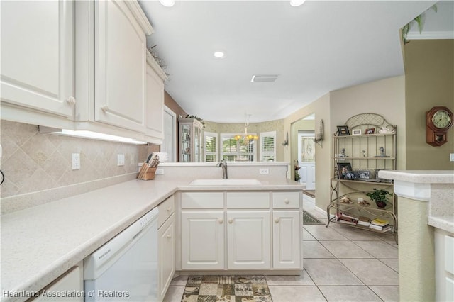 kitchen with kitchen peninsula, white cabinets, sink, and white dishwasher