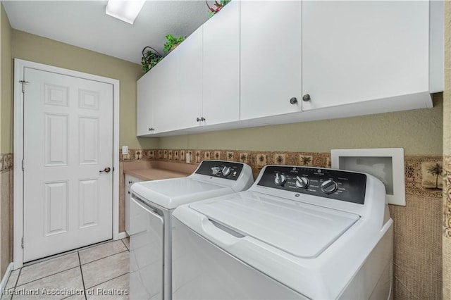 washroom featuring light tile patterned flooring, cabinets, and separate washer and dryer