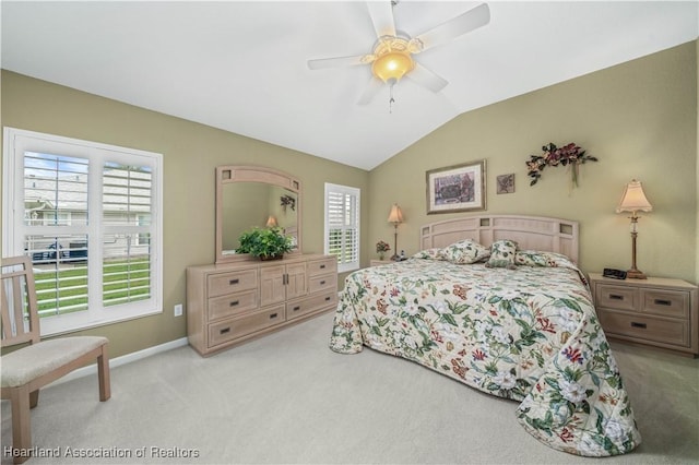 carpeted bedroom with ceiling fan and vaulted ceiling