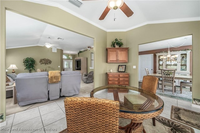 tiled dining area with ceiling fan with notable chandelier, lofted ceiling, and ornamental molding