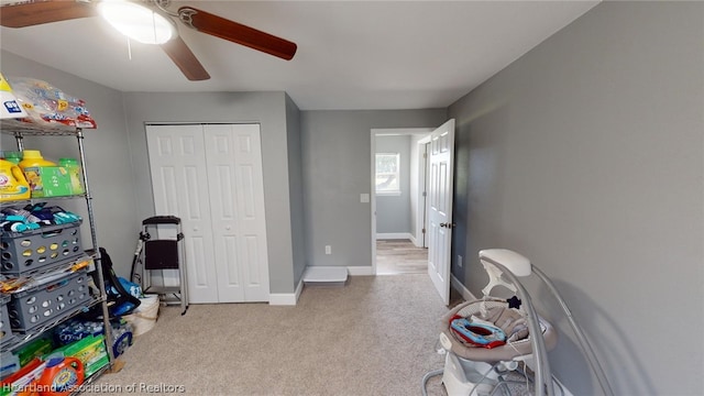 interior space with ceiling fan and light colored carpet