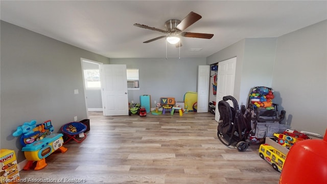 rec room with light wood-type flooring and ceiling fan