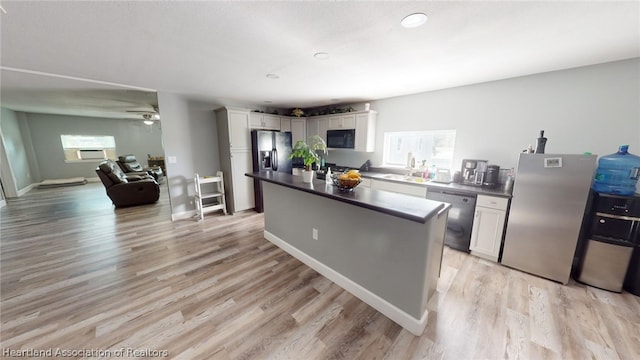 kitchen with white cabinets, light wood-type flooring, and dishwasher