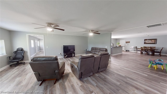 living room featuring ceiling fan and light wood-type flooring