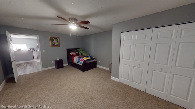 bedroom with a closet, ceiling fan, and light carpet