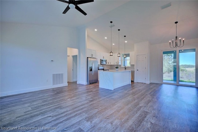 kitchen featuring a kitchen island, visible vents, white cabinets, open floor plan, and appliances with stainless steel finishes