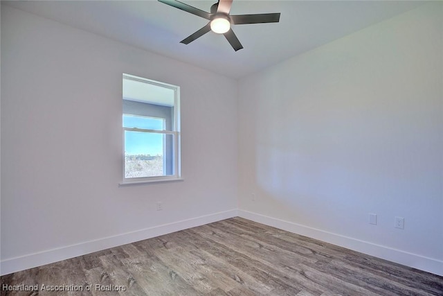 spare room featuring ceiling fan, wood finished floors, and baseboards