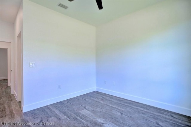 unfurnished room featuring baseboards, visible vents, ceiling fan, and wood finished floors