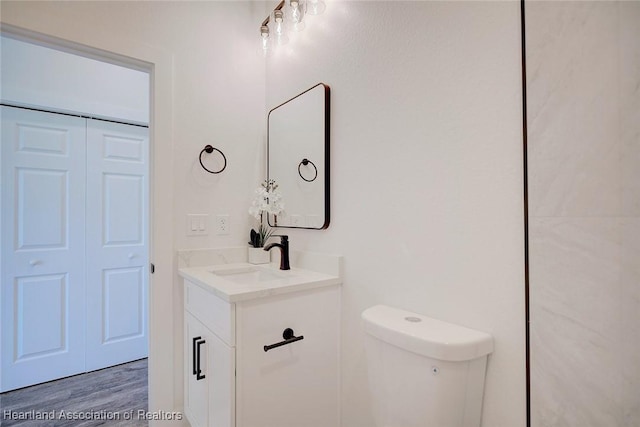 bathroom featuring toilet, wood finished floors, and vanity