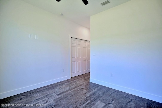 unfurnished room featuring ceiling fan, dark wood-type flooring, visible vents, and baseboards