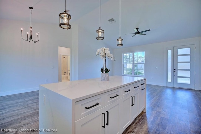 kitchen featuring wood finished floors, visible vents, open floor plan, hanging light fixtures, and a center island