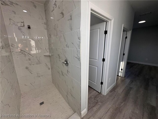 1940 Alan St, Sebring, FL 33875 - bathroom featuring wood-type flooring and tiled shower