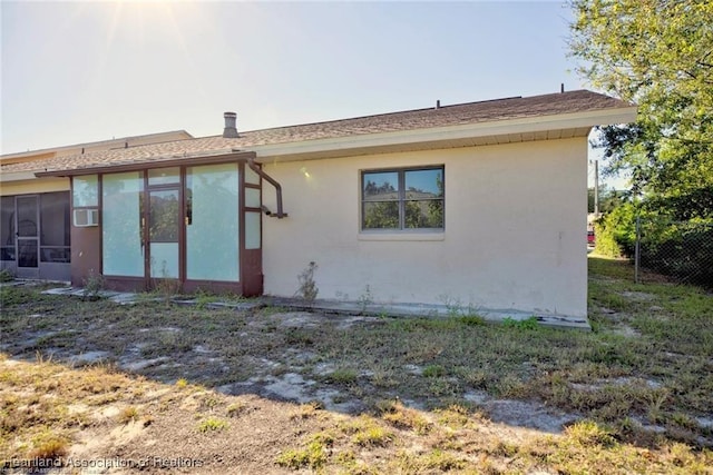 4524 Lafayette Ave, Sebring, FL 33875 - rear view of house with a sunroom, fence, and stucco siding