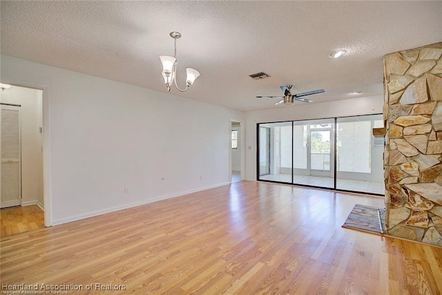 4524 Lafayette Ave, Sebring, FL 33875 - unfurnished living room with a textured ceiling, light wood-style flooring, ceiling fan, baseboards, and a chandelier
