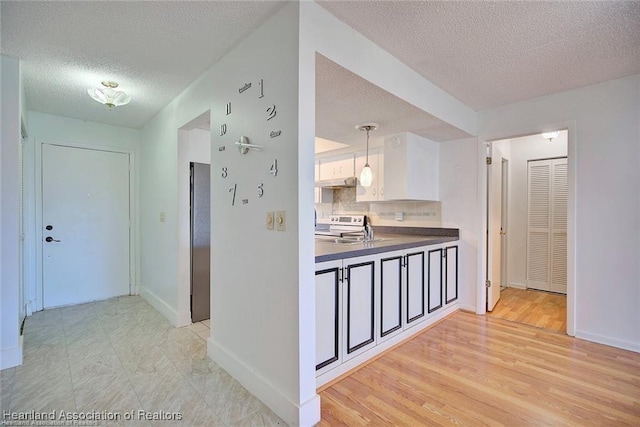 4524 Lafayette Ave, Sebring, FL 33875 - hall featuring a textured ceiling, baseboards, a sink, and light wood-type flooring