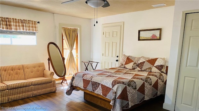 bedroom featuring visible vents, a ceiling fan, and wood finished floors